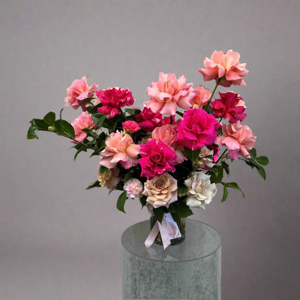 Bright red and pink rose bouquet on a plinth in a vase