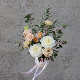 Elegant Mother's Day flower arrangement 'Marshmallow' featuring white roses, peach carnations, and seasonal blooms in soft pastel tones.