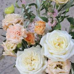 Close-up of 'Marshmallow' Mother's Day flower arrangement showcasing white roses, peach carnations, and delicate seasonal flowers.